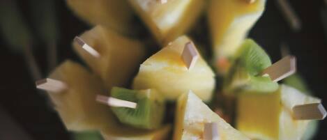 Primer plano de brochetas de frutas con palitos de madera.