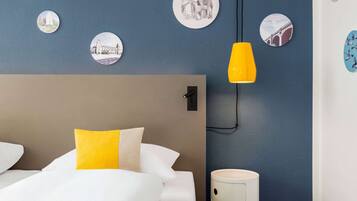 Ein Hotelzimmer mit Bett, Nachttisch, Lampe und Wanddekorationen.