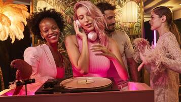 A DJ booth with a turntable, a microphone, and a plush toy.