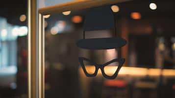 Una ventana decorada con un sombrero y gafas colgados.