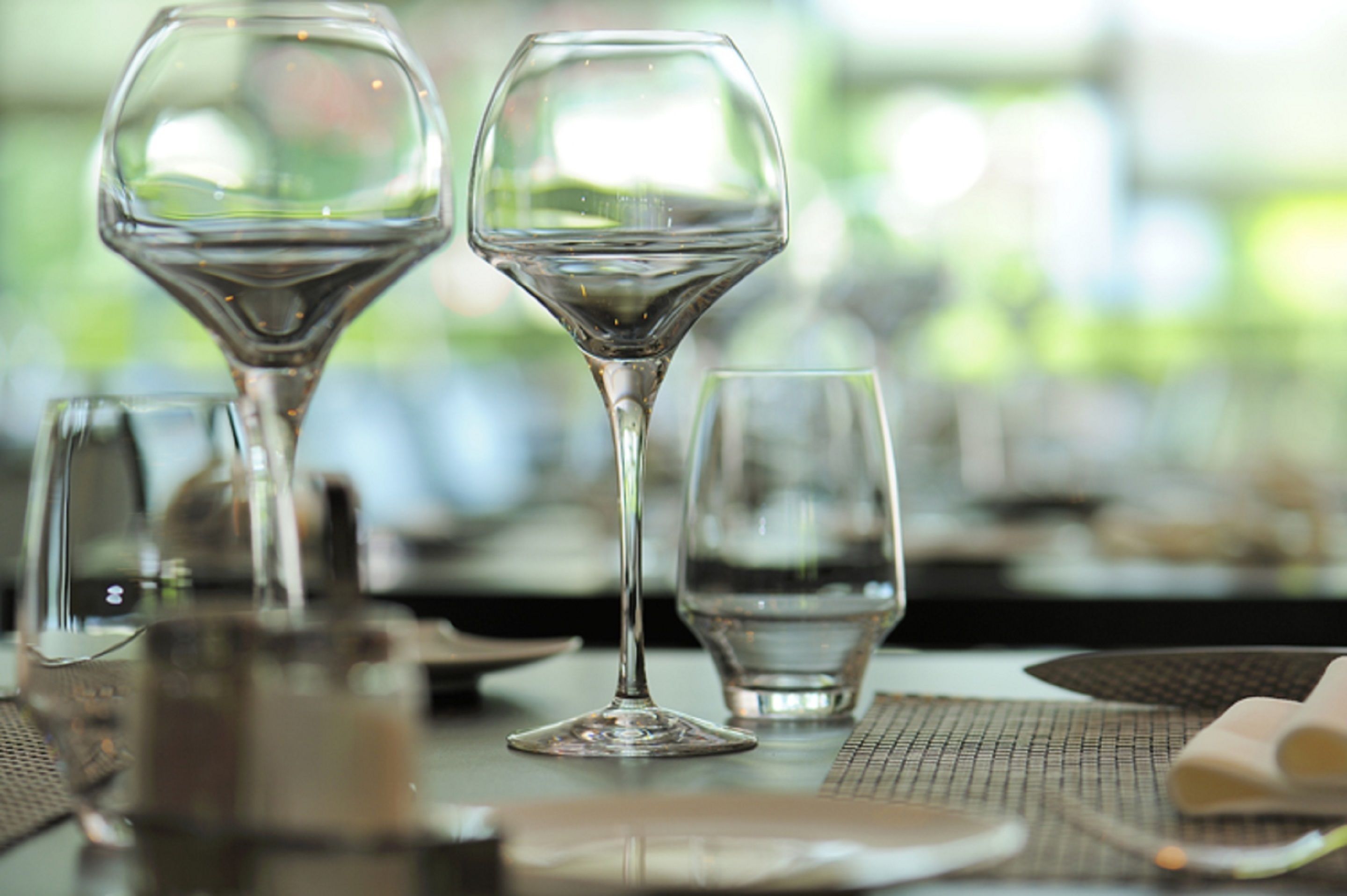 A table set with wine glasses, plates, and cutlery, indicating a dining area.