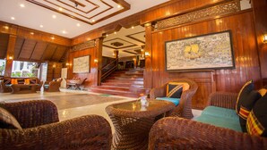 A lobby with wicker furniture, a staircase, and a large map on the wall. - Nova Samui Resort (Koh Samui)