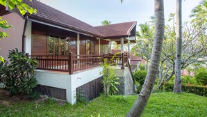 A two-story building with a balcony, surrounded by lush greenery and palm trees. - Nova Samui Resort (Koh Samui)