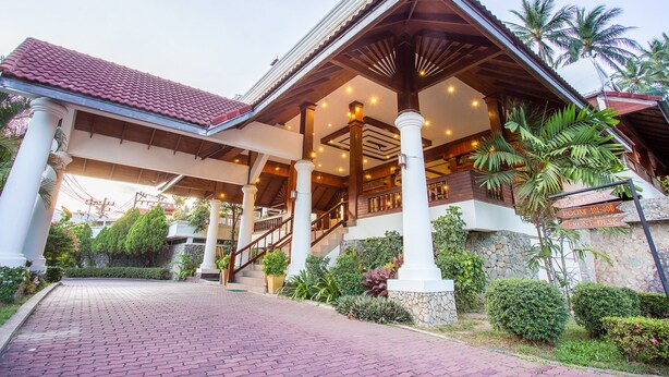 A hotel entrance with a red-tiled roof, a covered porch, and a staircase leading to the upper floors. - Nova Samui Resort (Koh Samui)