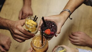 Un grupo de personas sosteniendo bebidas en una mesa.