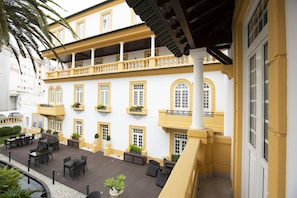 A building with multiple balconies, outdoor seating, and a pool area. - Veneza Hotel (Aveiro)