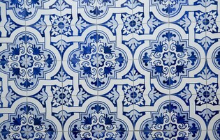 Una pared de azulejos con un motivo geométrico repetido.