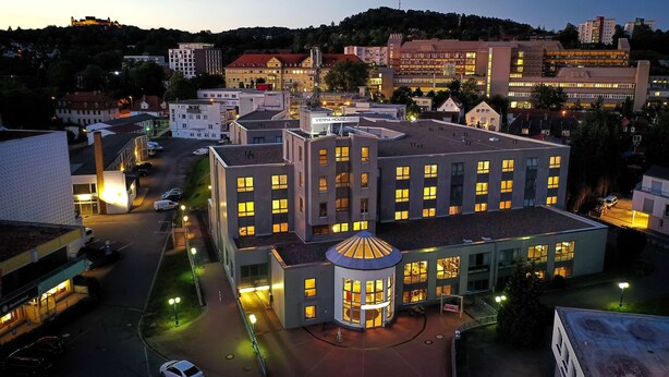 Un hotel con varios pisos, un patio central y una estructura en forma de torre redonda.