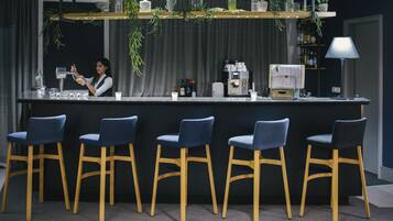 A bar area with a bartender, bar counter, and seating.