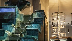 A staircase with water cascading down, a modern light fixture, and a bar area. - Mercure Hotel Hamm (Hamm)