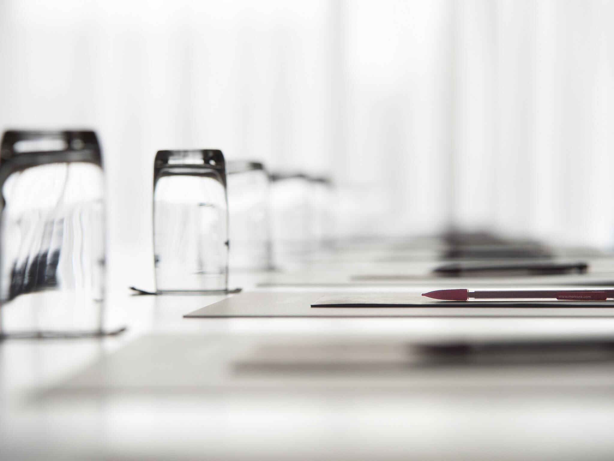 A conference room with a long table and chairs.
