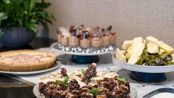 A dessert table with various cakes and pastries.