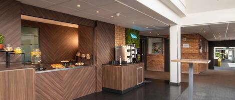 A reception area with a coffee station, water dispenser, and a sign indicating the location of the medical room.