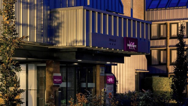 Een hotel met een moderne gevel, borden met 'Mercure Hotels' en een restaurant genaamd 'Restaurant de Hanz'.