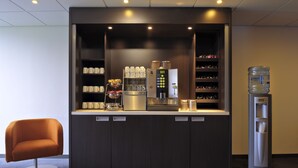A modern kitchenette with a coffee machine, water dispenser, and storage shelves. - Mercure City Zwolle Hotel (Zwolle)