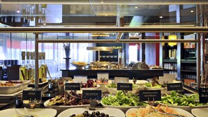 Ein Buffet mit verschiedenen Salaten und Speisen, darunter eine Oliven-Schale und ein Salat mit geriebenen Karotten.