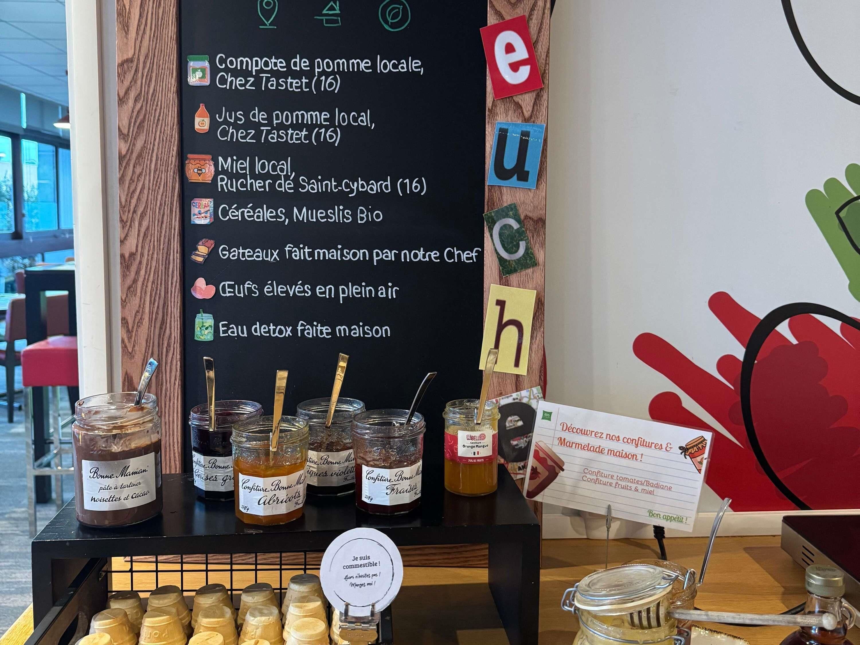 A display of local honey jars, jams, and a sign with food items.