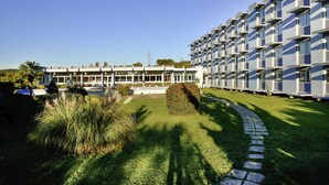A modern building with a row of balconies, a well-maintained lawn, and a clear sky. - ibis Styles Angouleme Nord (Champniers)