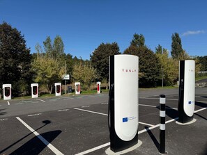Un estacionamiento con varias estaciones de carga para vehículos eléctricos Tesla.