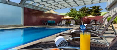 Una piscina al aire libre, tumbonas