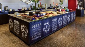 A buffet area with a variety of food options including pizza, olives, salads, and dishes with spices and cheese. - Novotel Sao Paulo Center Norte (São Paulo)