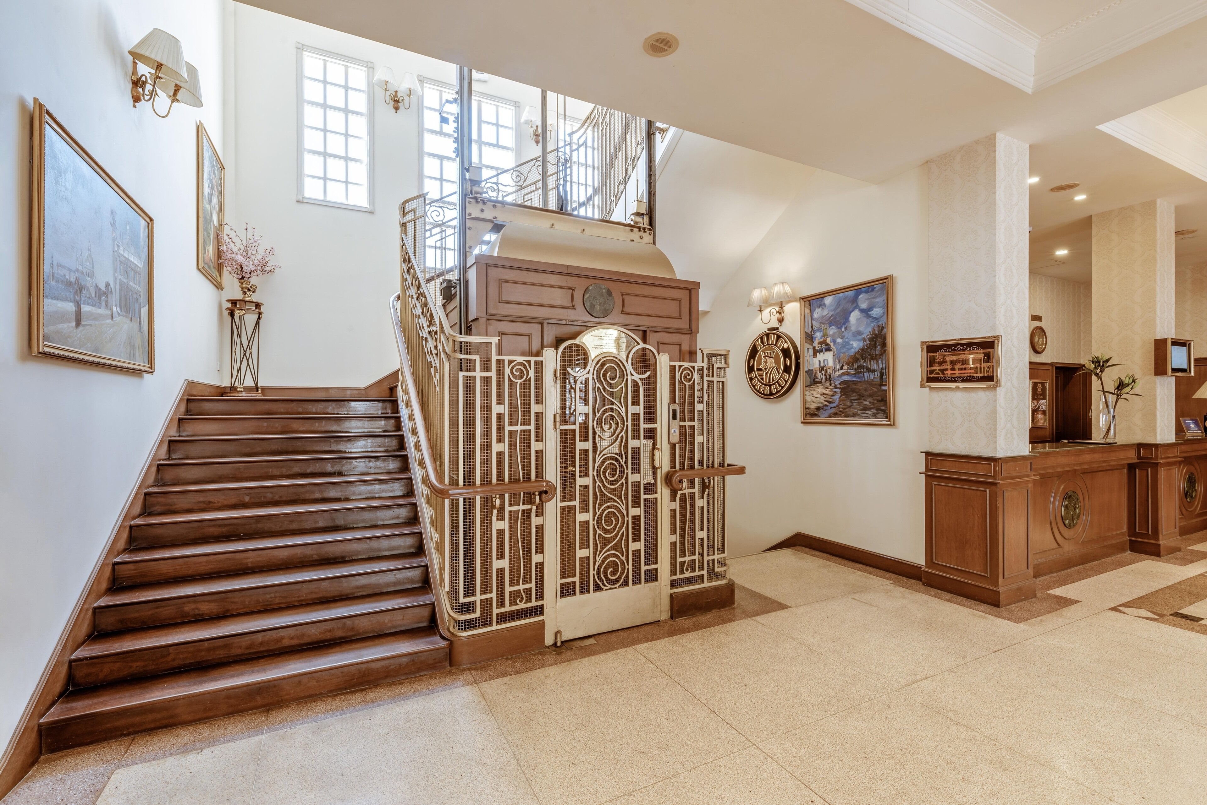Un magnifique escalier avec des rampes richement décorées, un revêtement en bois et un panneau mural ornemental.