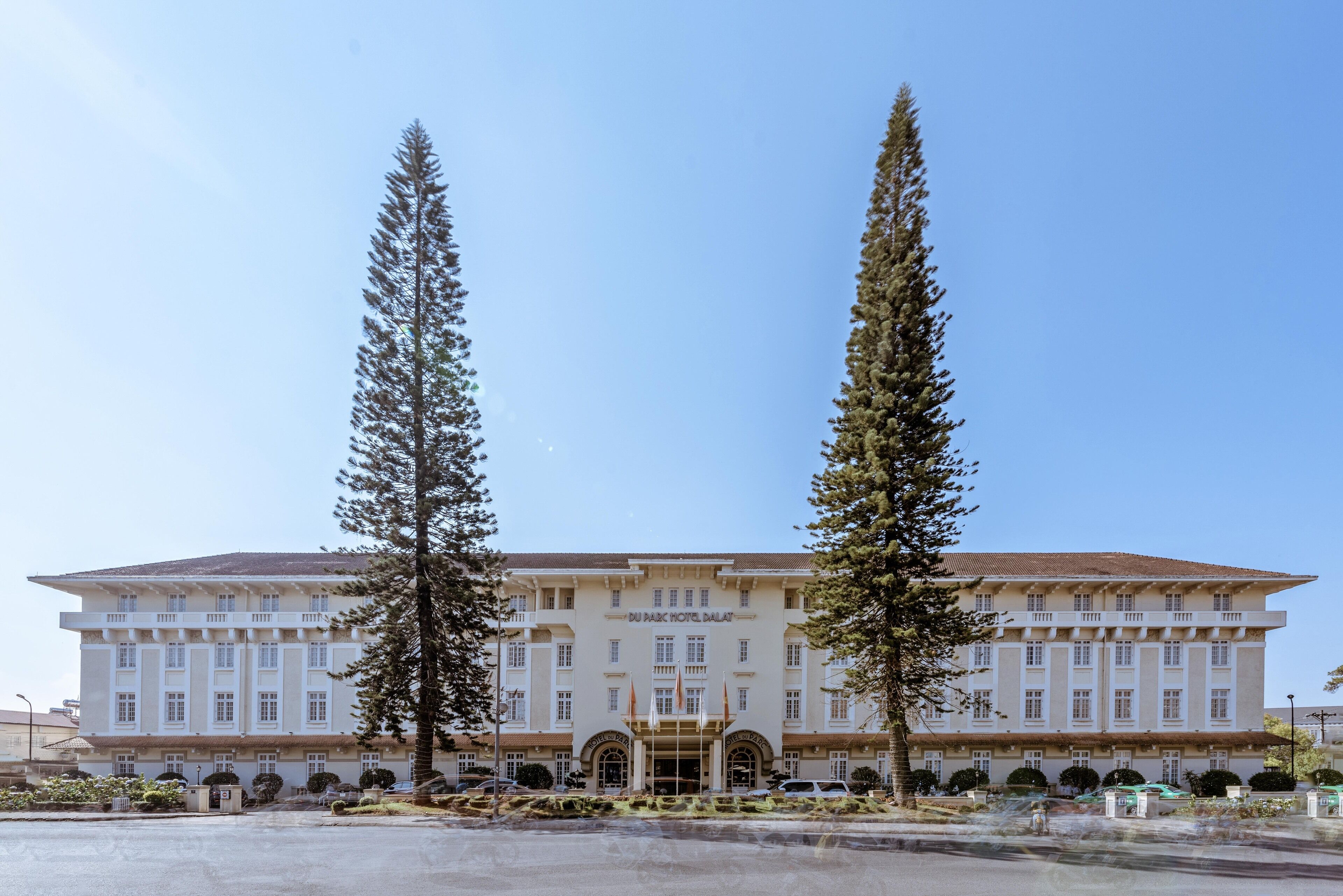 A large, multi-story hotel with a symmetrical facade, featuring a central entrance with a portico and multiple windows.