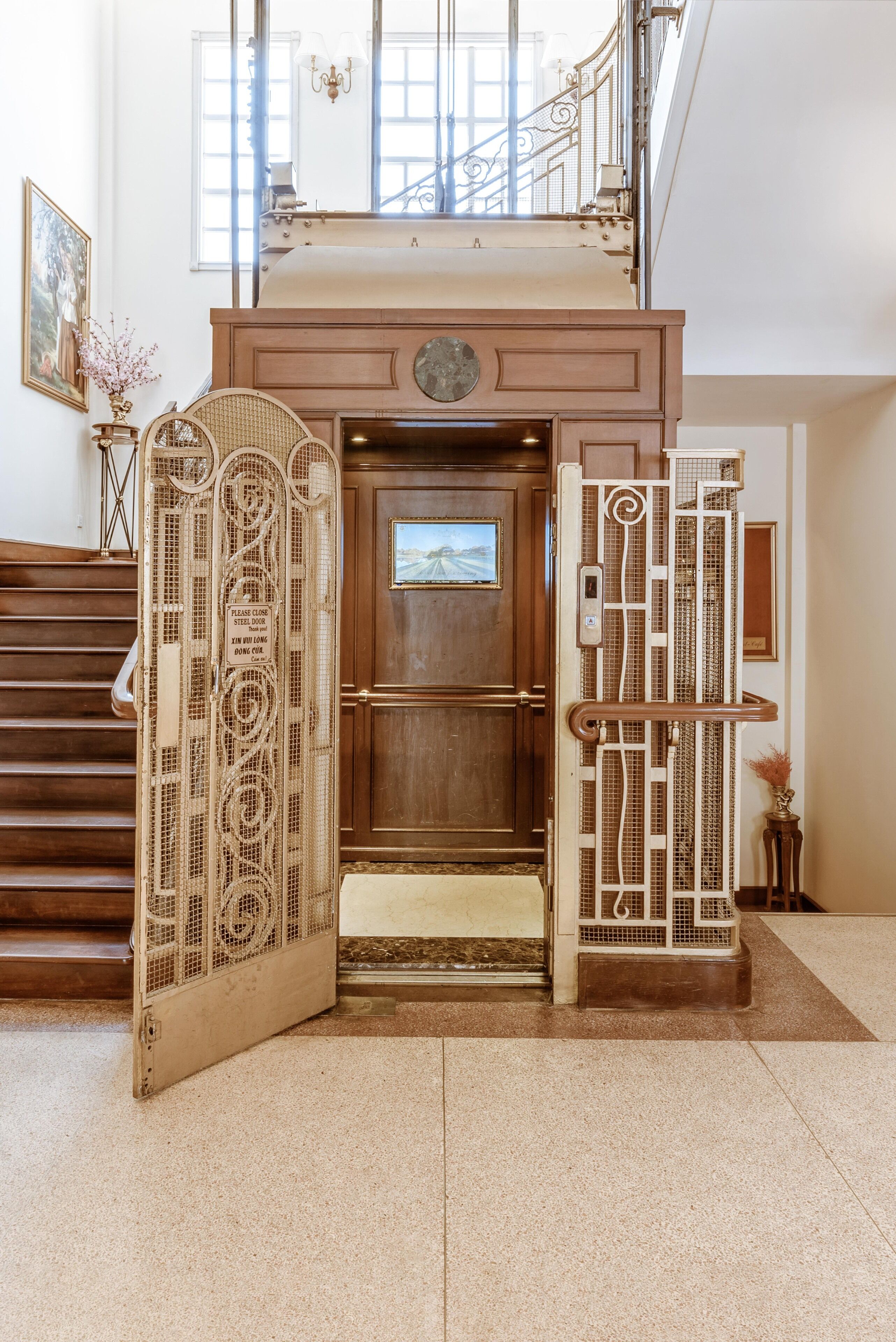 A grand entrance with a wooden door, a staircase, and a decorative gate.