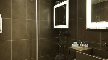 A modern bathroom with a glass-enclosed shower, a vanity with a sink, and a mirror.