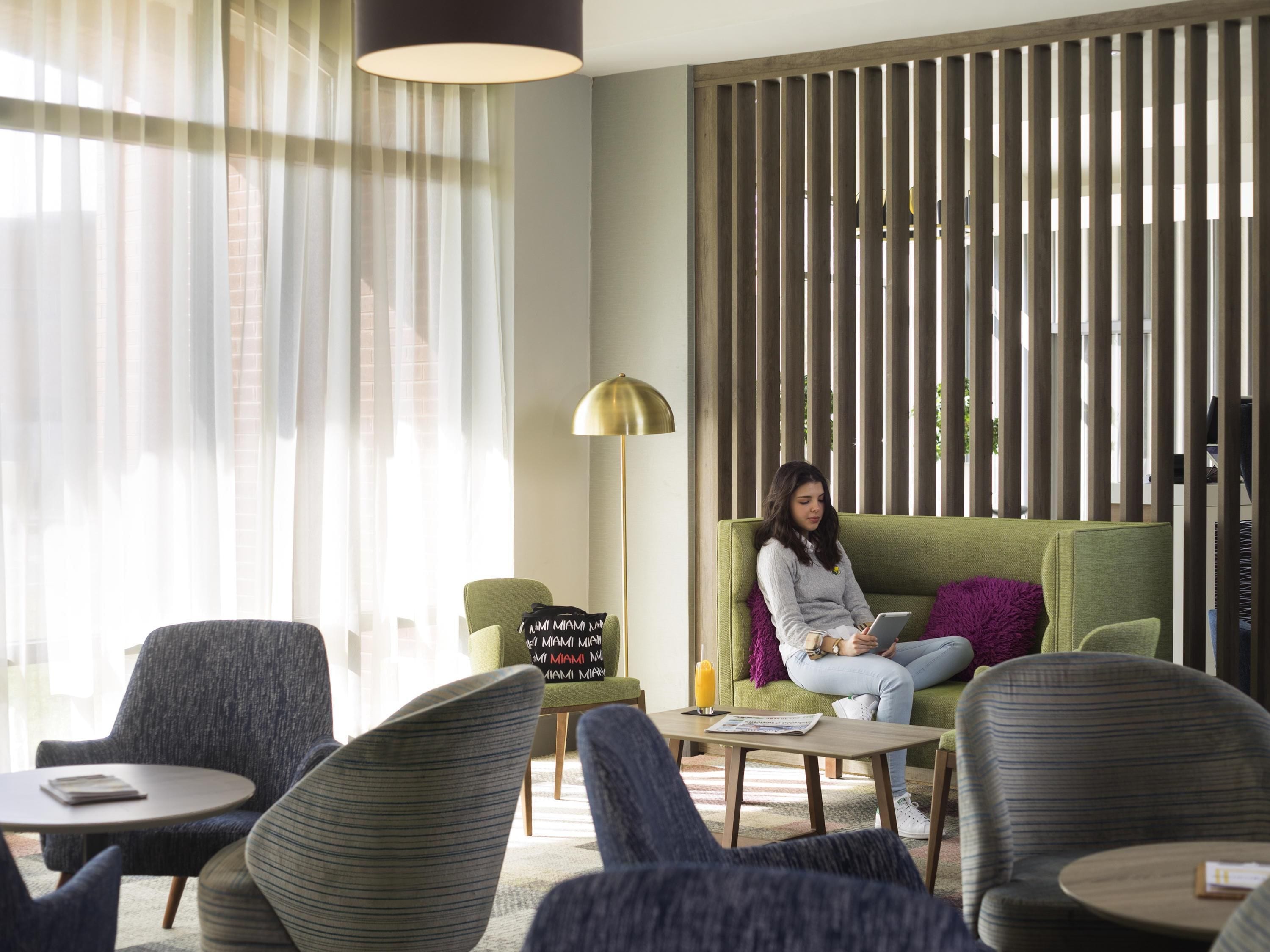 Un área de descanso moderna con sofá, sillones y una mesa de centro.