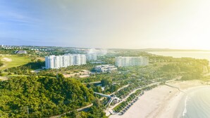 A resort with multiple high-rise buildings, a golf course, and a beach.