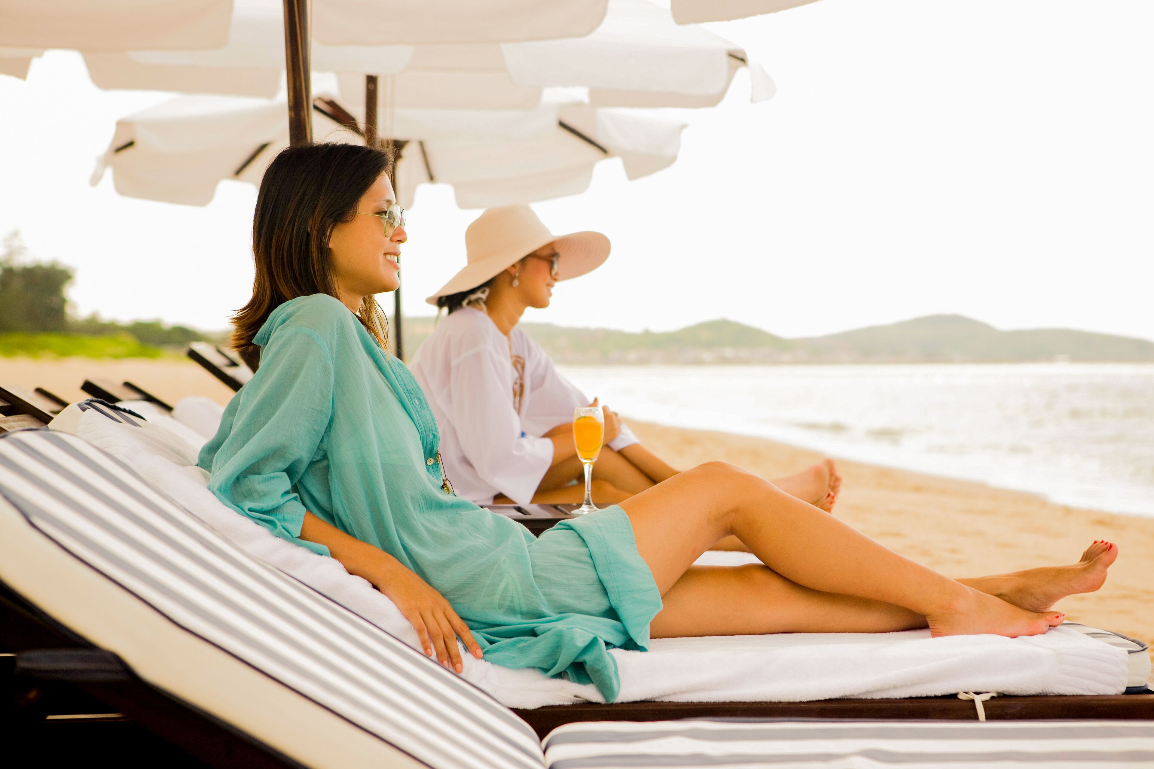 Am Strand, weißer Sandstrand, Liegestühle, Sonnenschirme