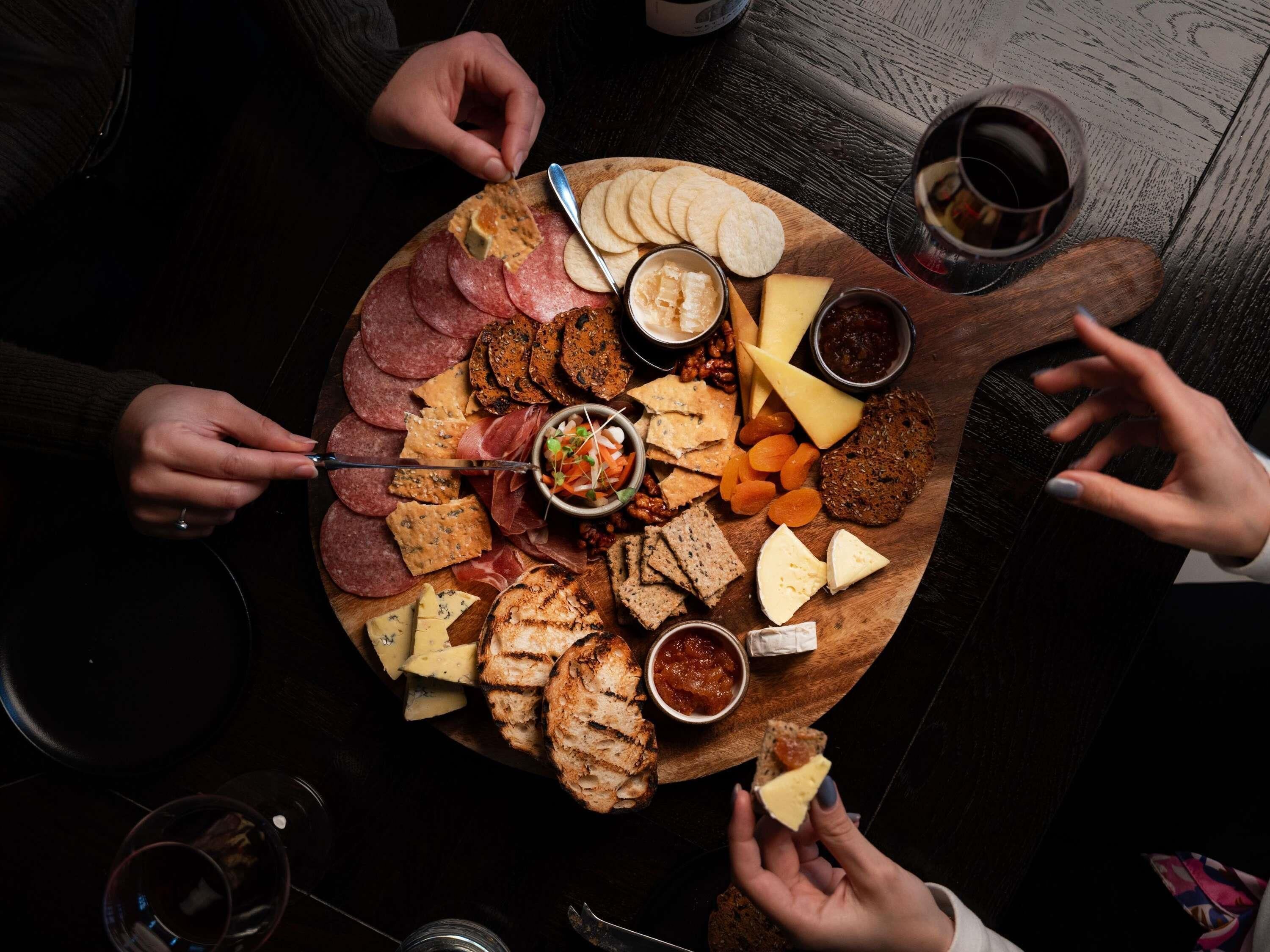 A charcuterie board with various cheeses, meats, and crackers.
