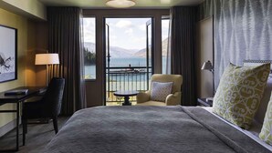 A hotel room with a large bed, a desk, a chair, and a view of the sea. - Hotel St Moritz, Queenstown - MGallery (Queenstown)