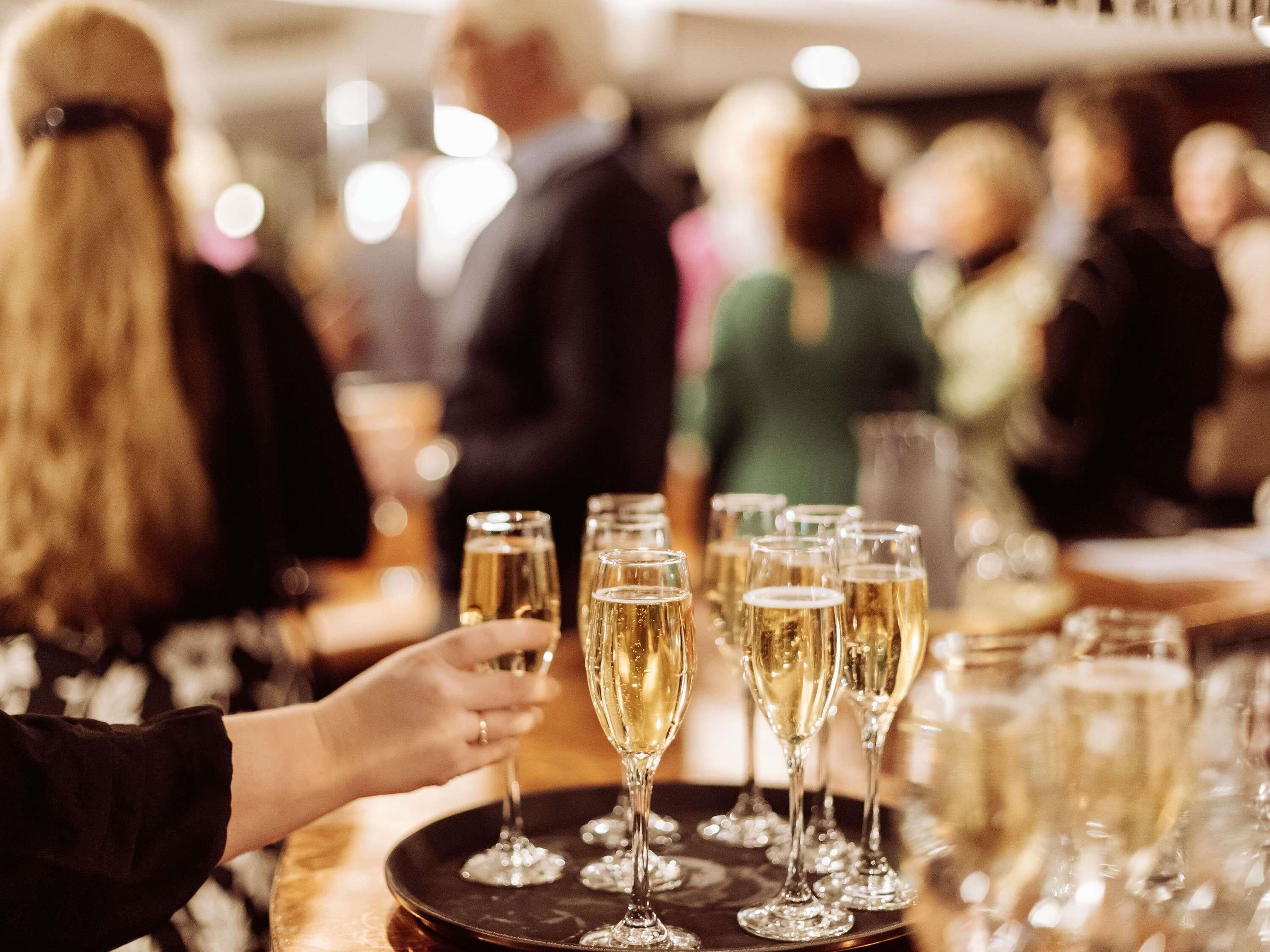 Un grupo de personas chocando copas, sugiriendo un evento social o una celebración.