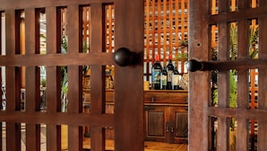 A wooden partition with a door, behind which there is a bar area with bottles and a cabinet. - Axis Vermar Conference & Beach Hotel (Povoa De Varzim)