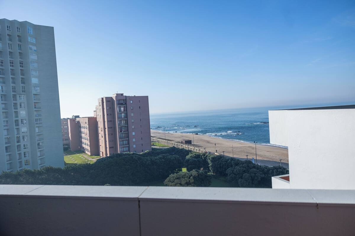 A high-rise building overlooking a beach with a clear view of the ocean.
