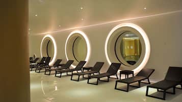 Une rangée de chaises longues, des miroirs ronds fixés au mur, un sol impeccable et un plafond bien éclairé.