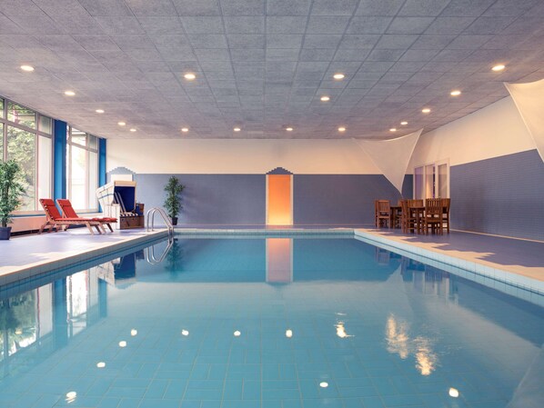 Relax by the pool with lounge chairs and a table nearby.