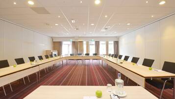 A conference room with a long table, chairs, and a striped carpet.