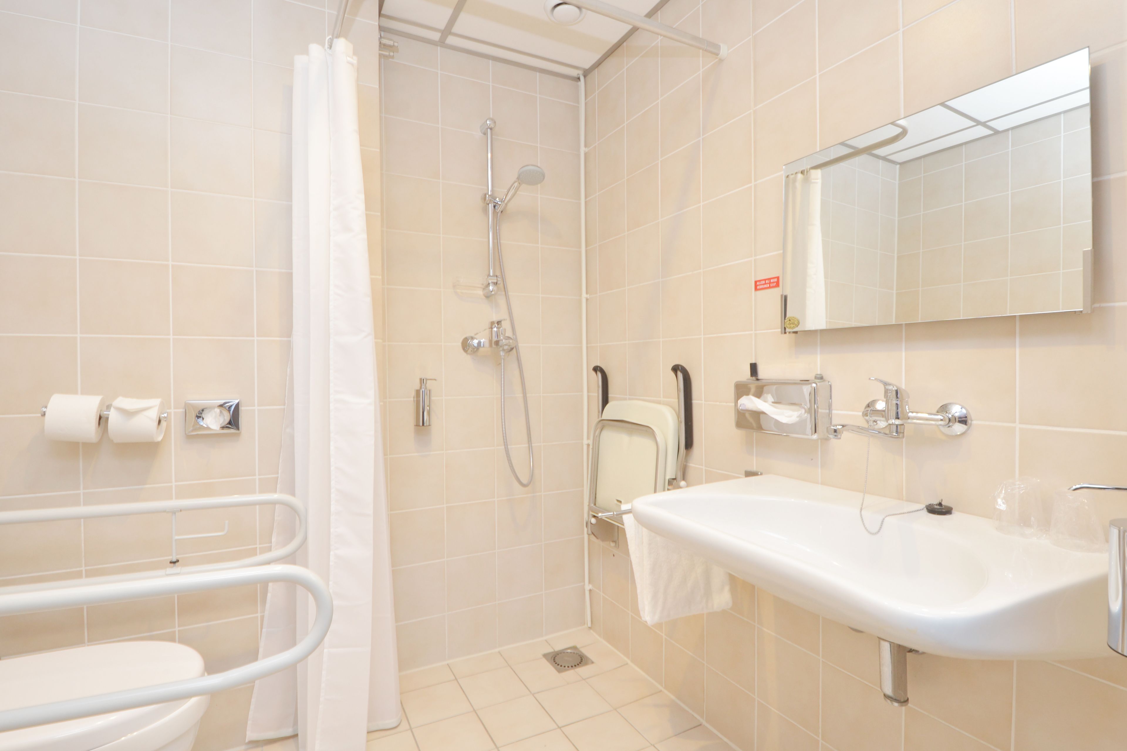 A modern bathroom with a shower, toilet, and sink.
