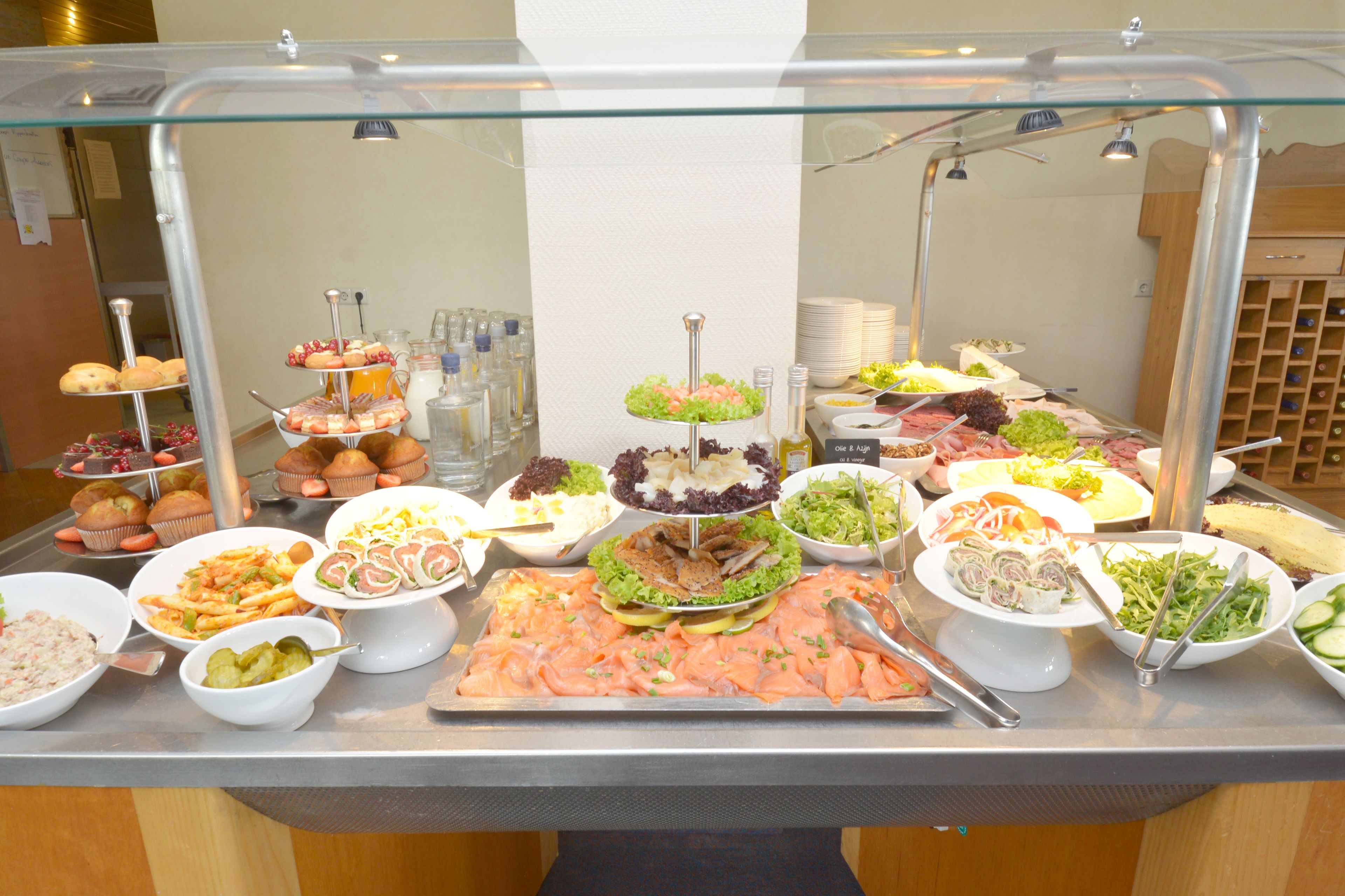 A buffet with various food items including salads, meats, and pastries.