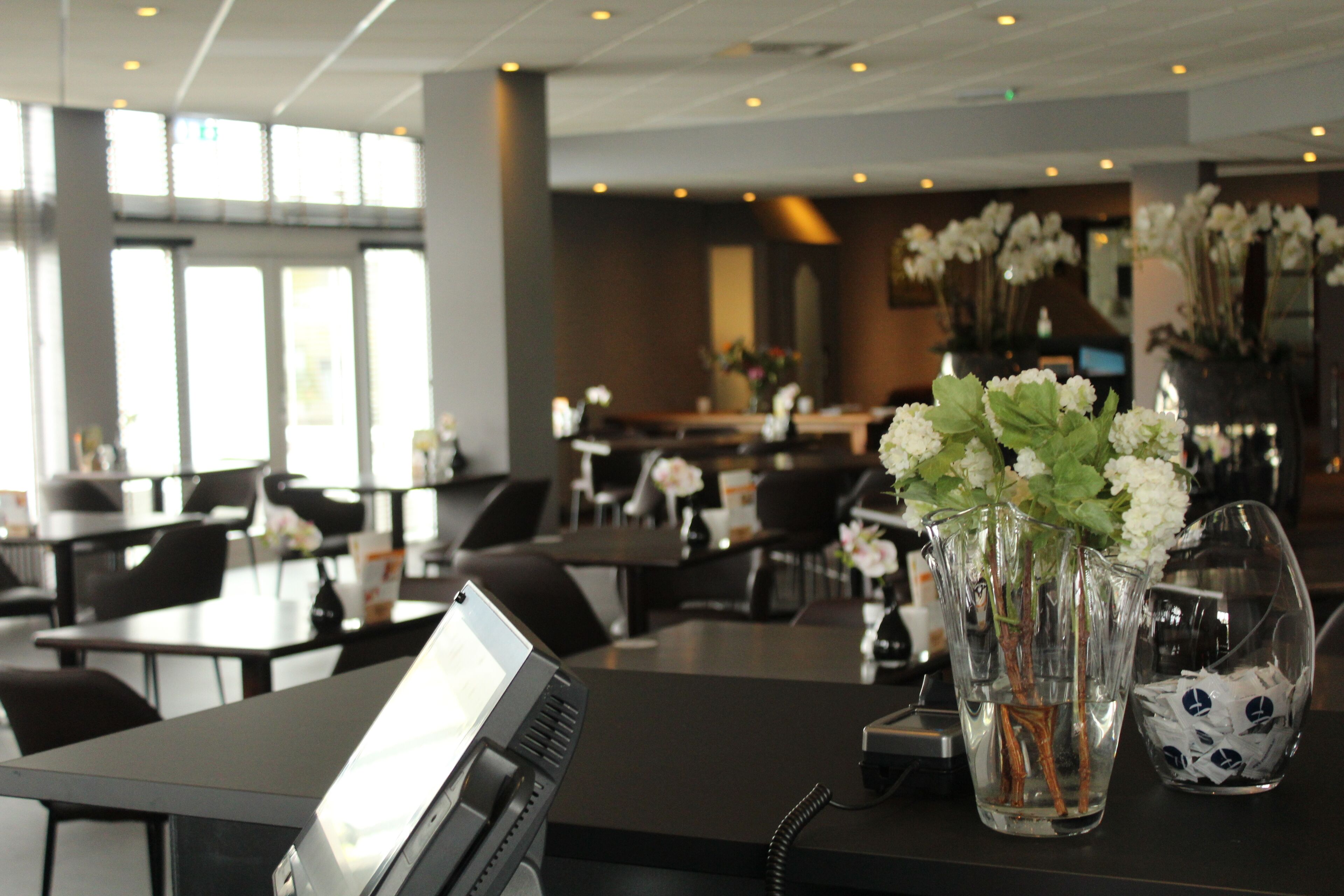En hotellobby med bord, stolar och en receptionsdisk.
