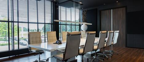 A modern conference room with a long table, six chairs, and large windows.