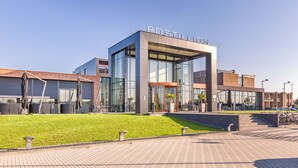A modern building with a glass facade and the name "POSTULION" on the top. - Postillion Hotel Utrecht Bunnik (Bunnik)