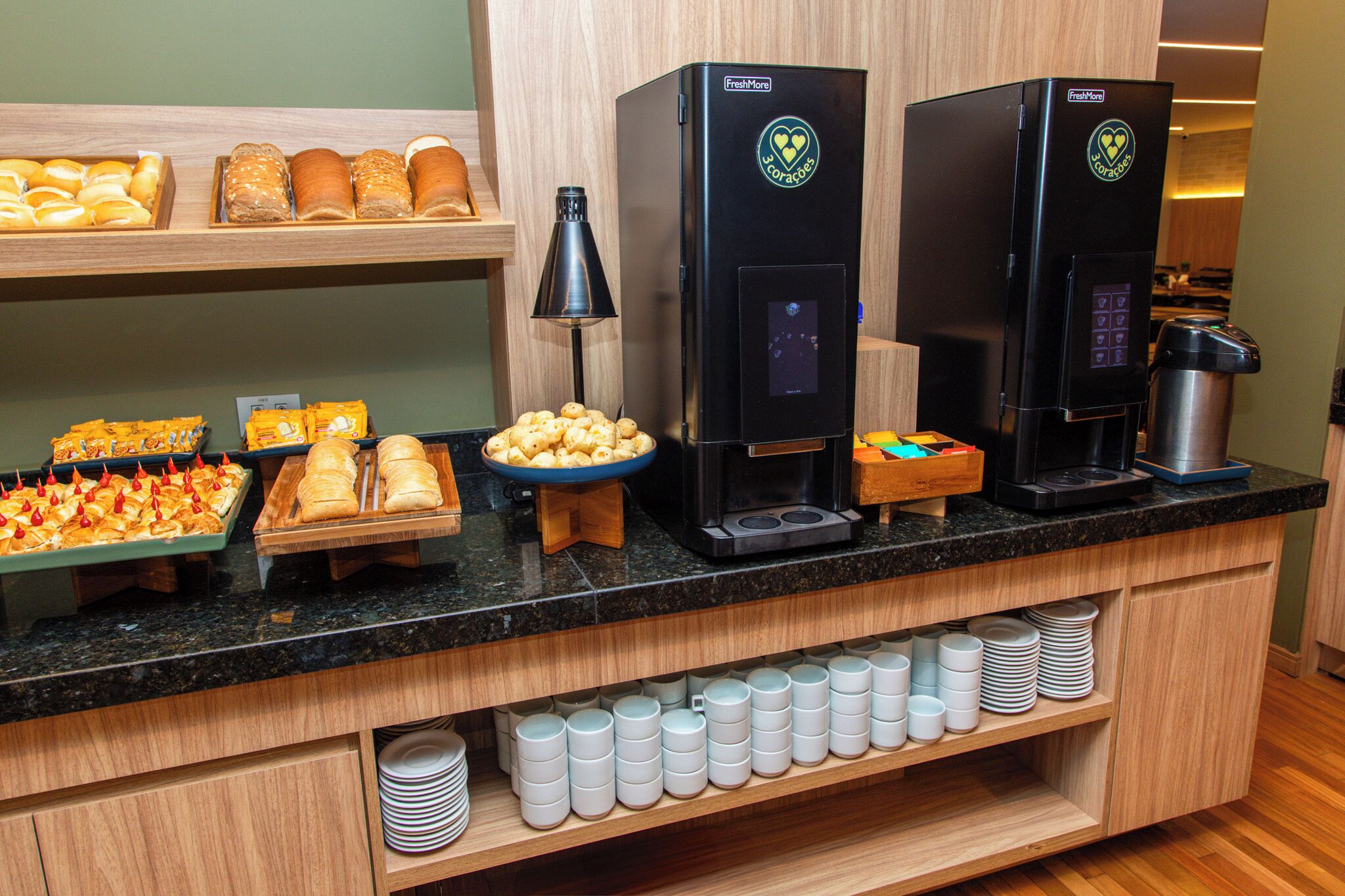 Un bufé de desayuno con diferentes alimentos y máquinas de café.