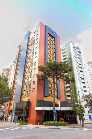 A multi-story hotel with a modern facade, balconies, and a visible entrance. - SLAVIERO Curitiba Shopping (Curitiba)