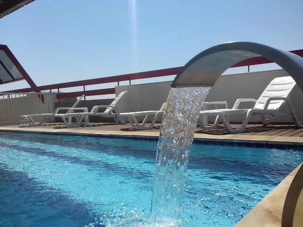 Outdoor pool, open 6:00 AM to 10:00 PM, pool loungers