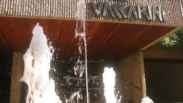 A building entrance with a water feature in front.