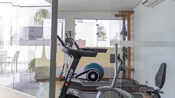 A modern home gym with a treadmill, stationary bike, and exercise equipment.